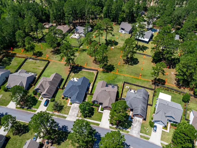 Aerial view of a suburban Mississippi neighborhood with marked sewer easement corridors across backyards